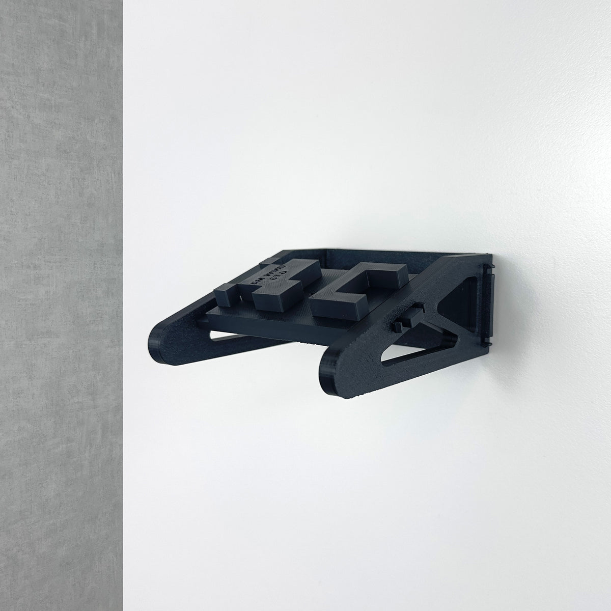 Close-up of the black BrickNest 3D-printed wall mount for securely displaying the LEGO BMW M4 GT3 race car