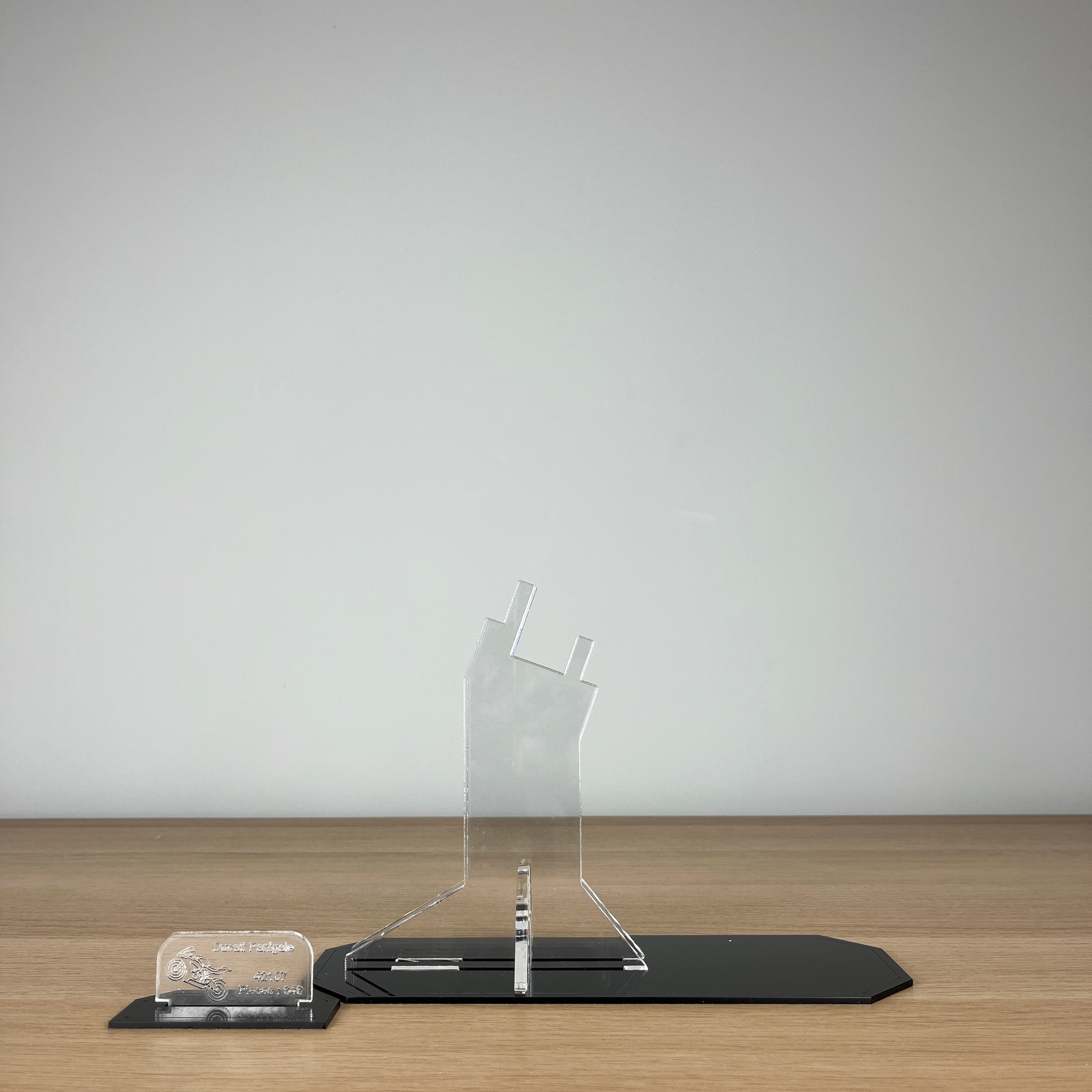 Clear Lego acrylic display stand on a wooden surface with a plain background