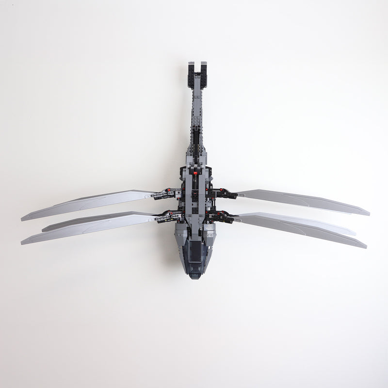 Vertical wall mount display stand holding LEGO® Dune Atreides Royal Ornithopter 10327 model, presenting the aircraft at a dynamic angle on the wall.
