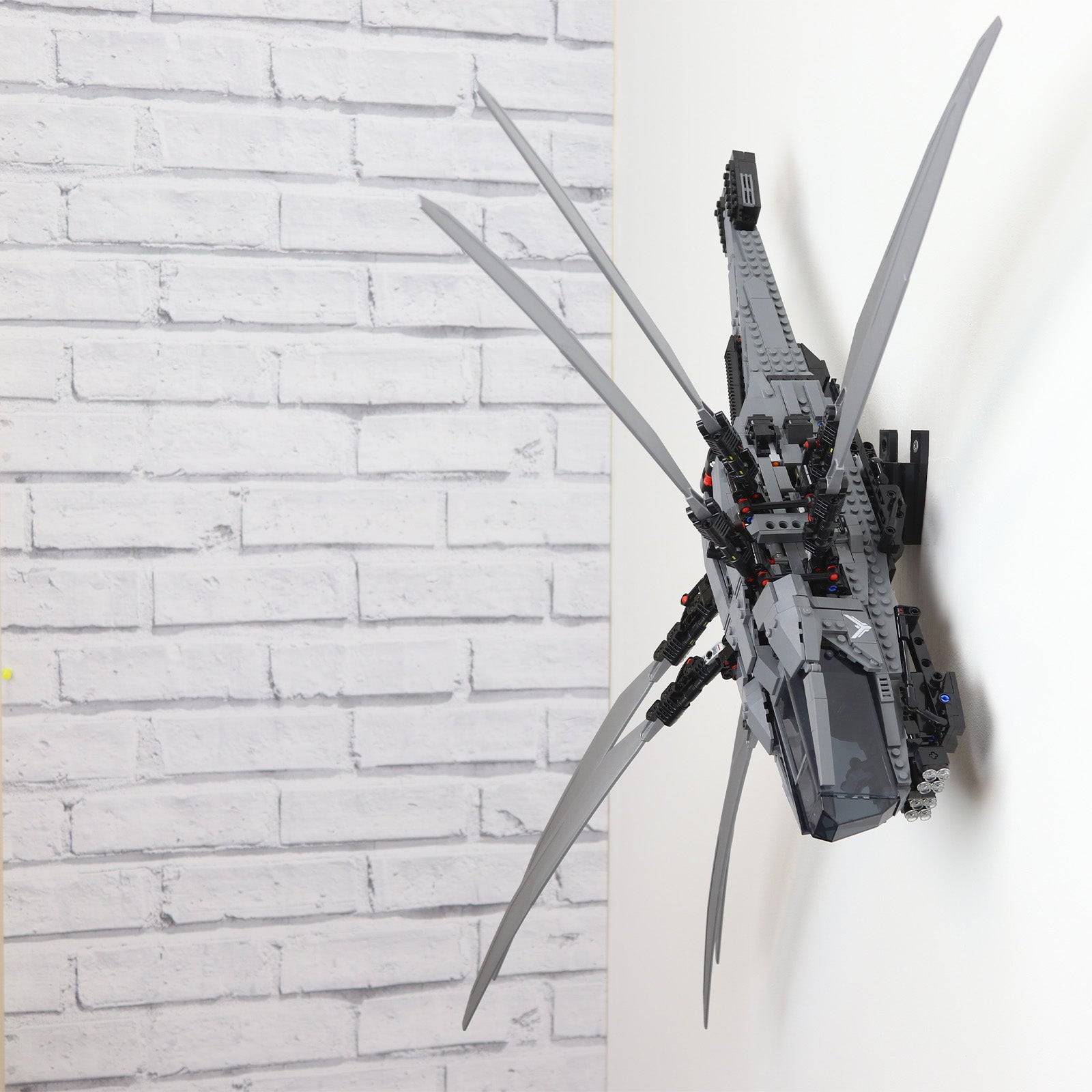 Vertical wall mount display stand holding LEGO® Dune Atreides Royal Ornithopter 10327 model, presenting the aircraft at a dynamic angle on the wall.
