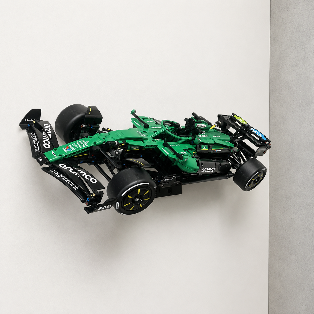 LEGO Technic Aston Martin Aramco AMR25 F1 Car 42240 displayed at a dynamic angle on a black BrickNest wall mount against a clean white wall