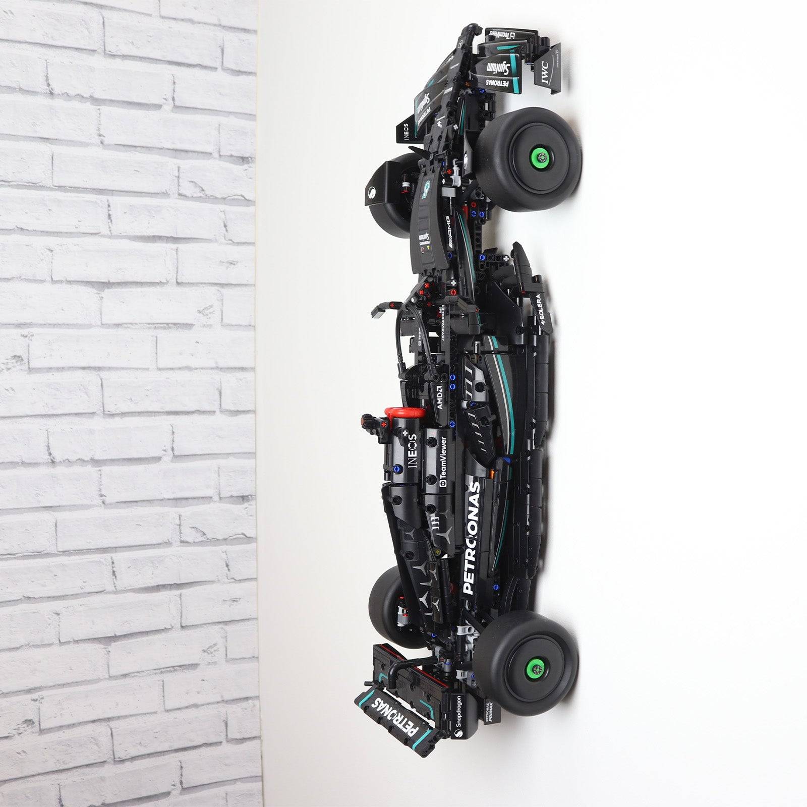 Vertical wall display mount holding LEGO® Technic Mercedes F1 Car 42171 model, showcasing the car at an angled position on the wall.
