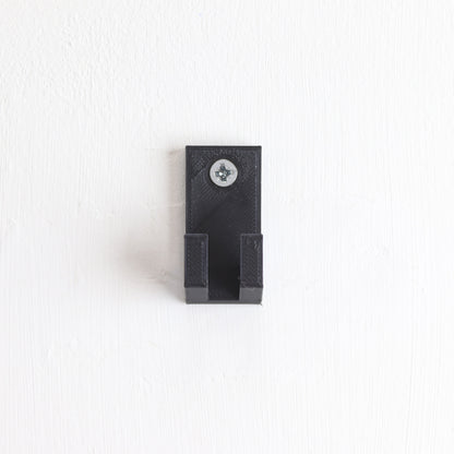 Vertical wall display mount holding LEGO® Technic Mercedes F1 Car 42171 model, showcasing the car at an angled position on the wall.
