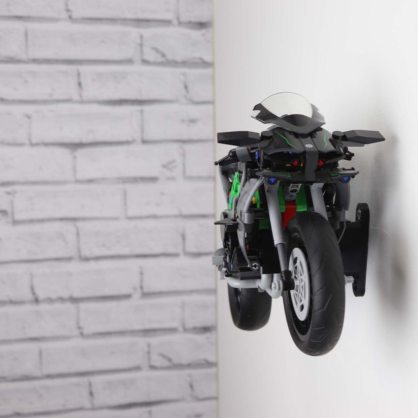Wall display mount holding LEGO® Kawasaki Ninja Motorcycle (42170) model, displaying the motorcycle at an angled position on the wall for an attractive presentation.
