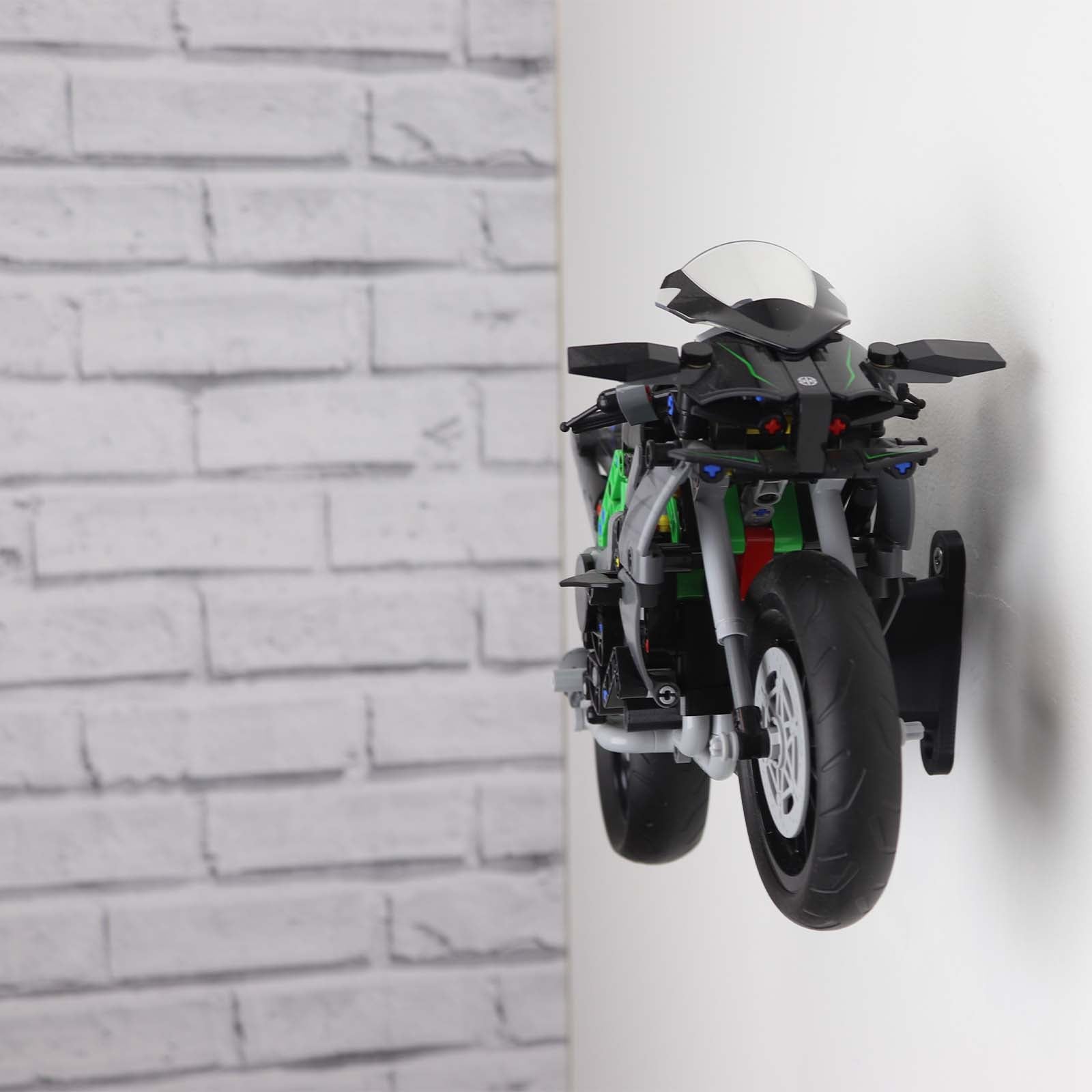 Wall display mount holding LEGO® Kawasaki Ninja Motorcycle (42170) model, displaying the motorcycle at an angled position on the wall for an attractive presentation.
