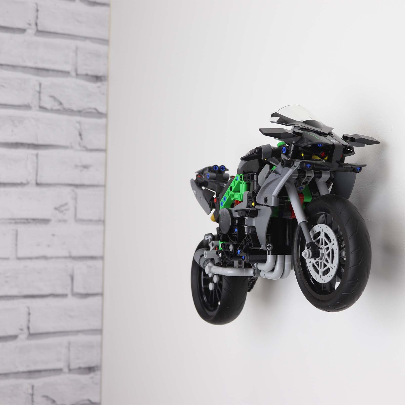 Wall display mount holding LEGO® Kawasaki Ninja Motorcycle (42170) model, displaying the motorcycle at an angled position on the wall for an attractive presentation.
