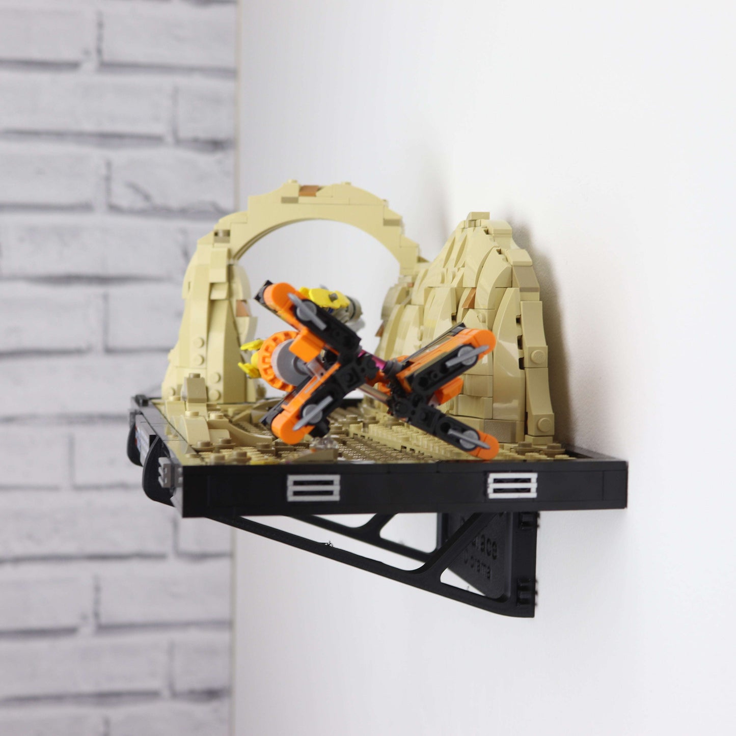 Wall mount display stand holding LEGO® Podrace Diorama (75380), showcasing the intricate scene at an angled position on the wall for an eye-catching display.
