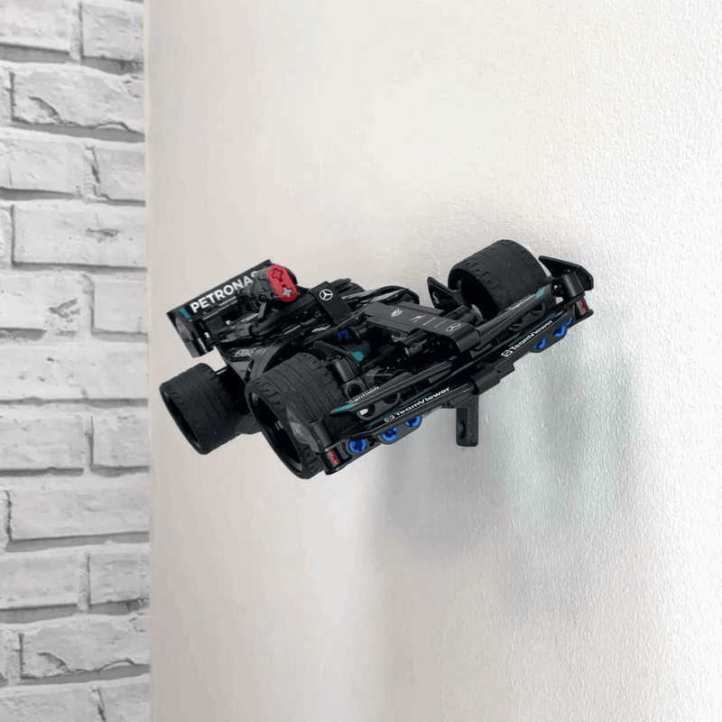 Wall display mount holding LEGO® Mercedes Speed Chaser F1 (42165) model, presenting the car at an angled position on the wall for a striking visual display.
