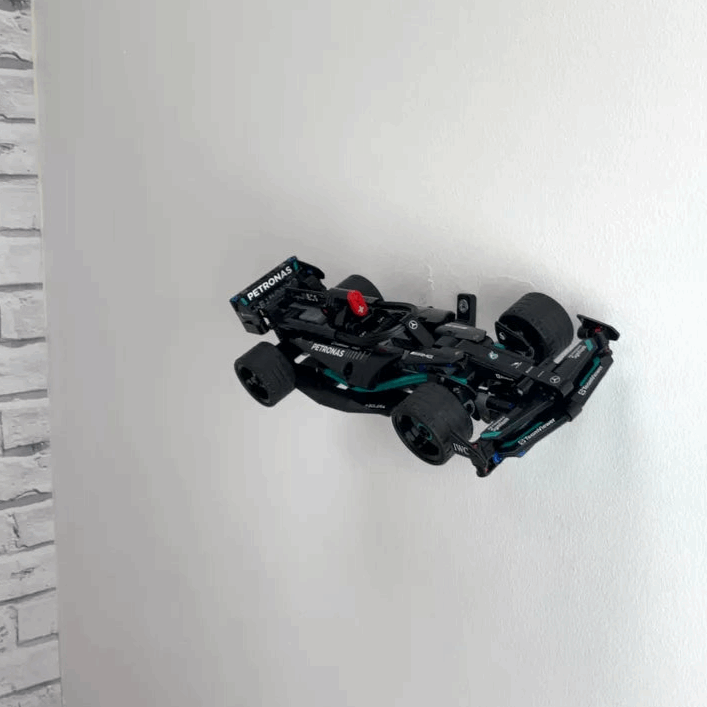 Wall display mount holding LEGO® Mercedes Speed Chaser F1 (42165) model, presenting the car at an angled position on the wall for a striking visual display.
