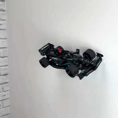 Wall display mount holding LEGO® Mercedes Speed Chaser F1 (42165) model, presenting the car at an angled position on the wall for a striking visual display.
